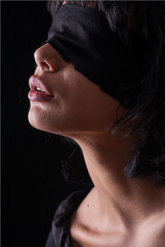 Woman wearing a black blindfold, symbolizing a journey toward healing and empowerment.